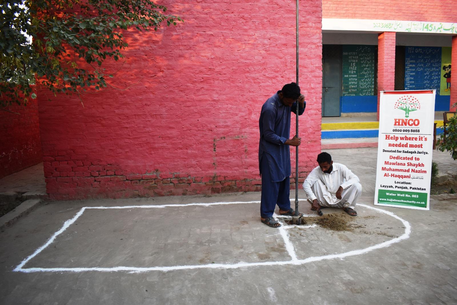 Workers drilling for water well installation at HNCO project site