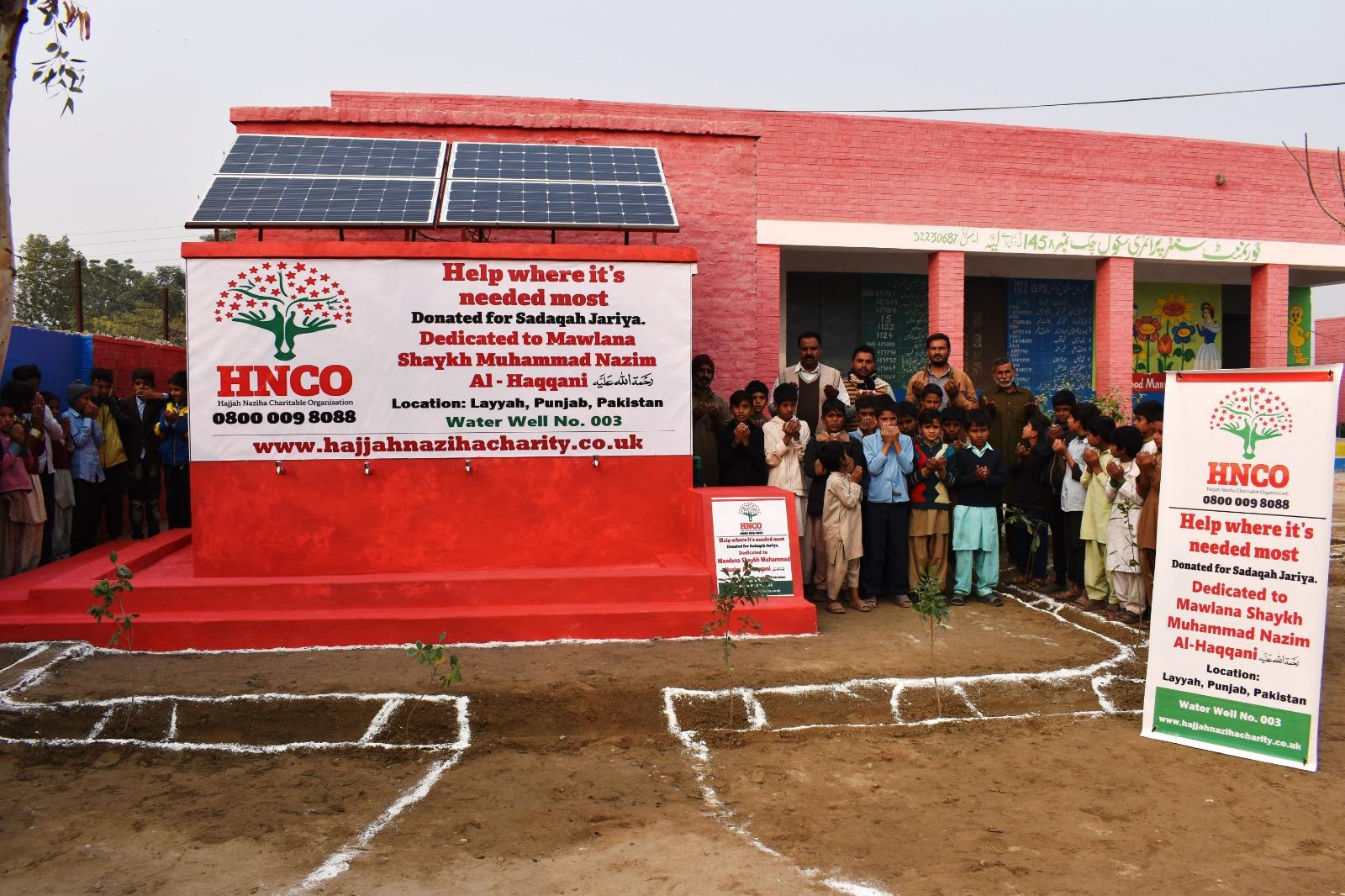Community gathering at completed HNCO solar water pump installation